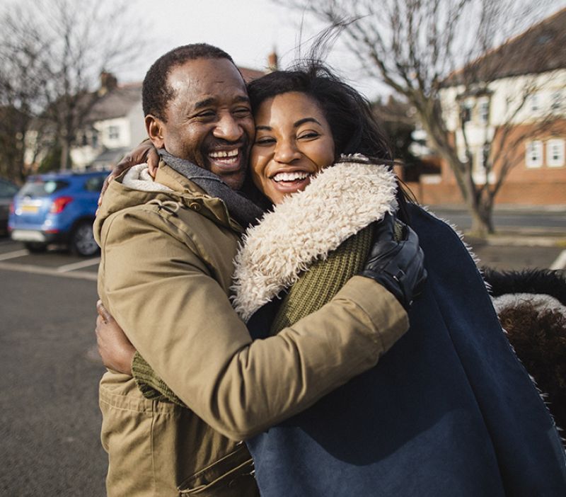 two adults embracing in a hug outdoors